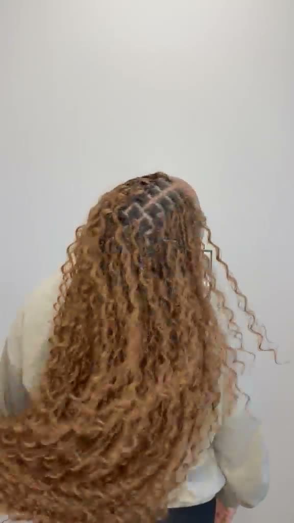Client revealing finished blonde ombre knotless braids in the mirror