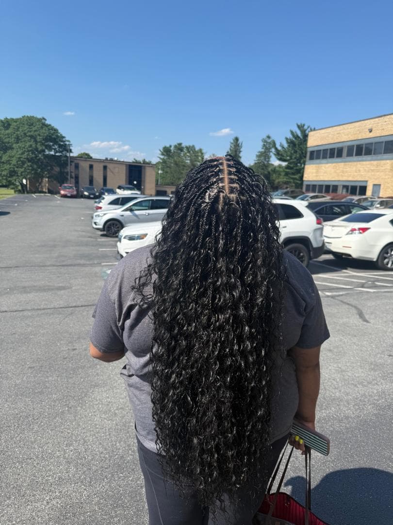 Long knotless braids with curly ends, styled by Irene's Hair Beauty in Baltimore, MD